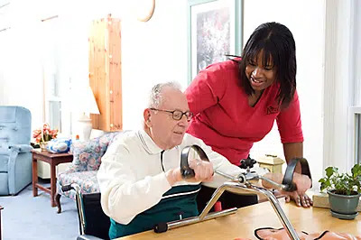 An occupational therapist working with a resident at a table