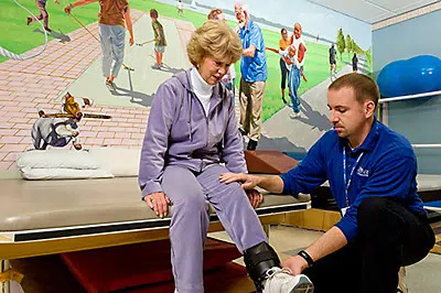 A therapist helping a resident exercise her legs