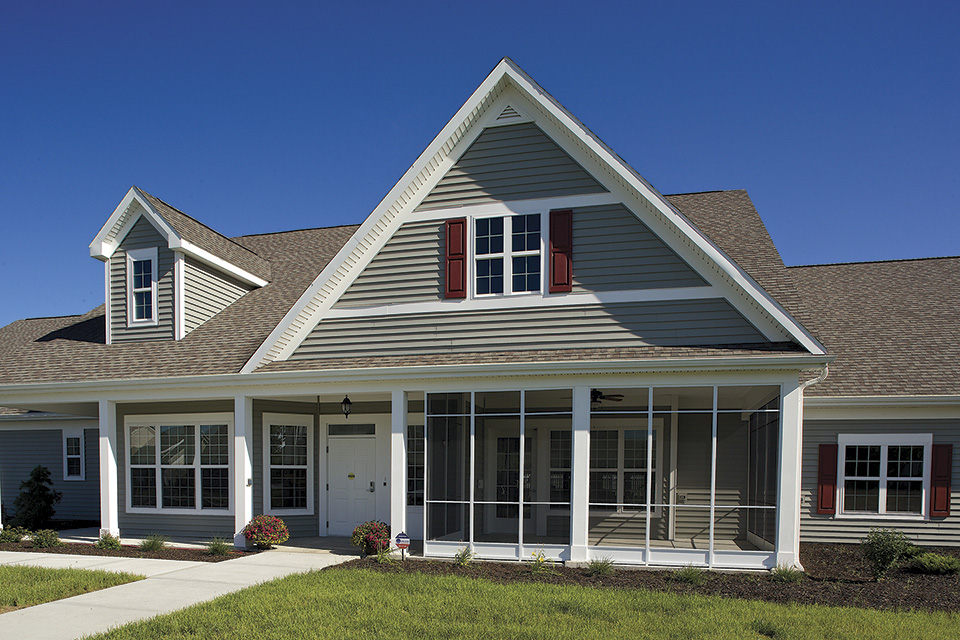 A cottage with a gabled roof and screened porch