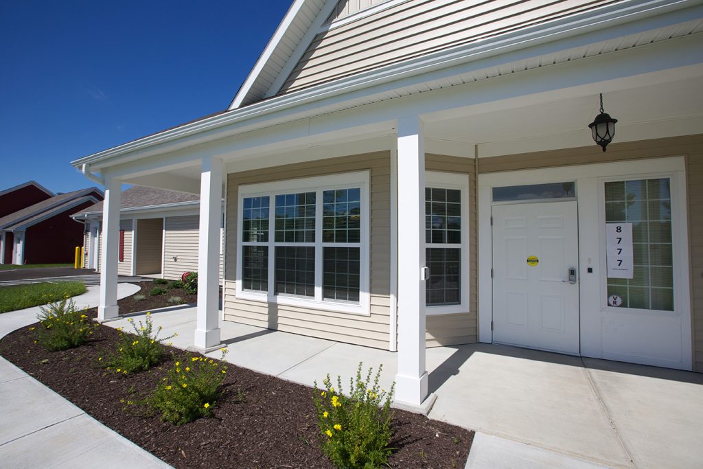 The front entrance of a cottage with a garden bed