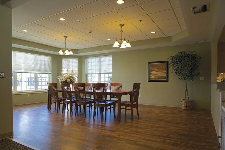 A bright dining room with a long wooden table