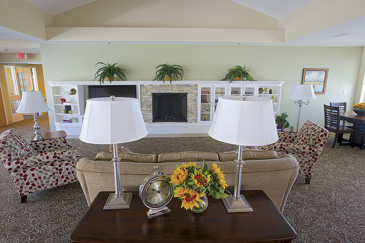 The hearth room, with a fireplace, sofas and armchairs