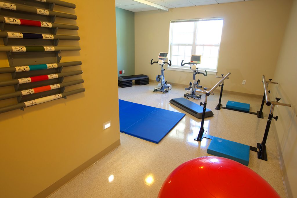 The therapy gym with parallel bars and exercise equipment
